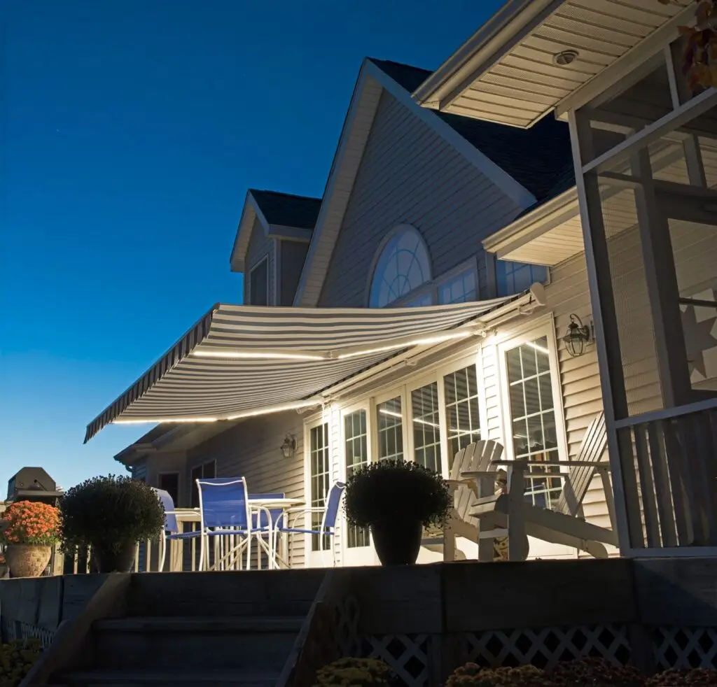 a house with a patio and chairs and a retractable awning