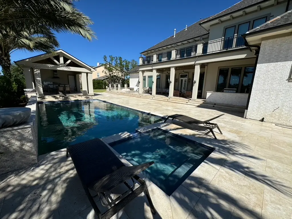 Luxury backyard pool with custom motorized patio screens and covered outdoor living space