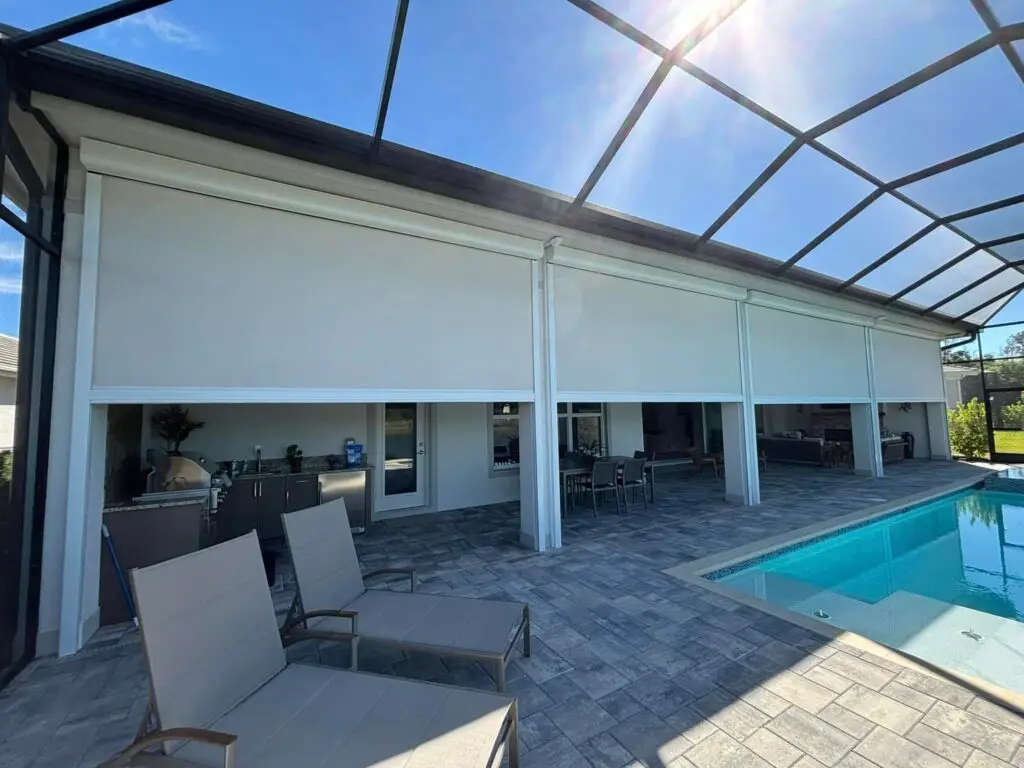 Luxury pool patio with motorized retractable screens lowered over covered outdoor living area
